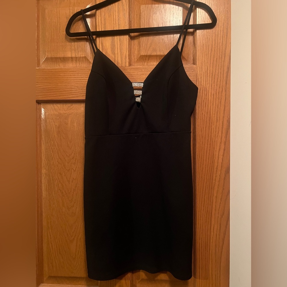 Black mini dress with 3 silver shiny on v neck. Size 4, stretchy material